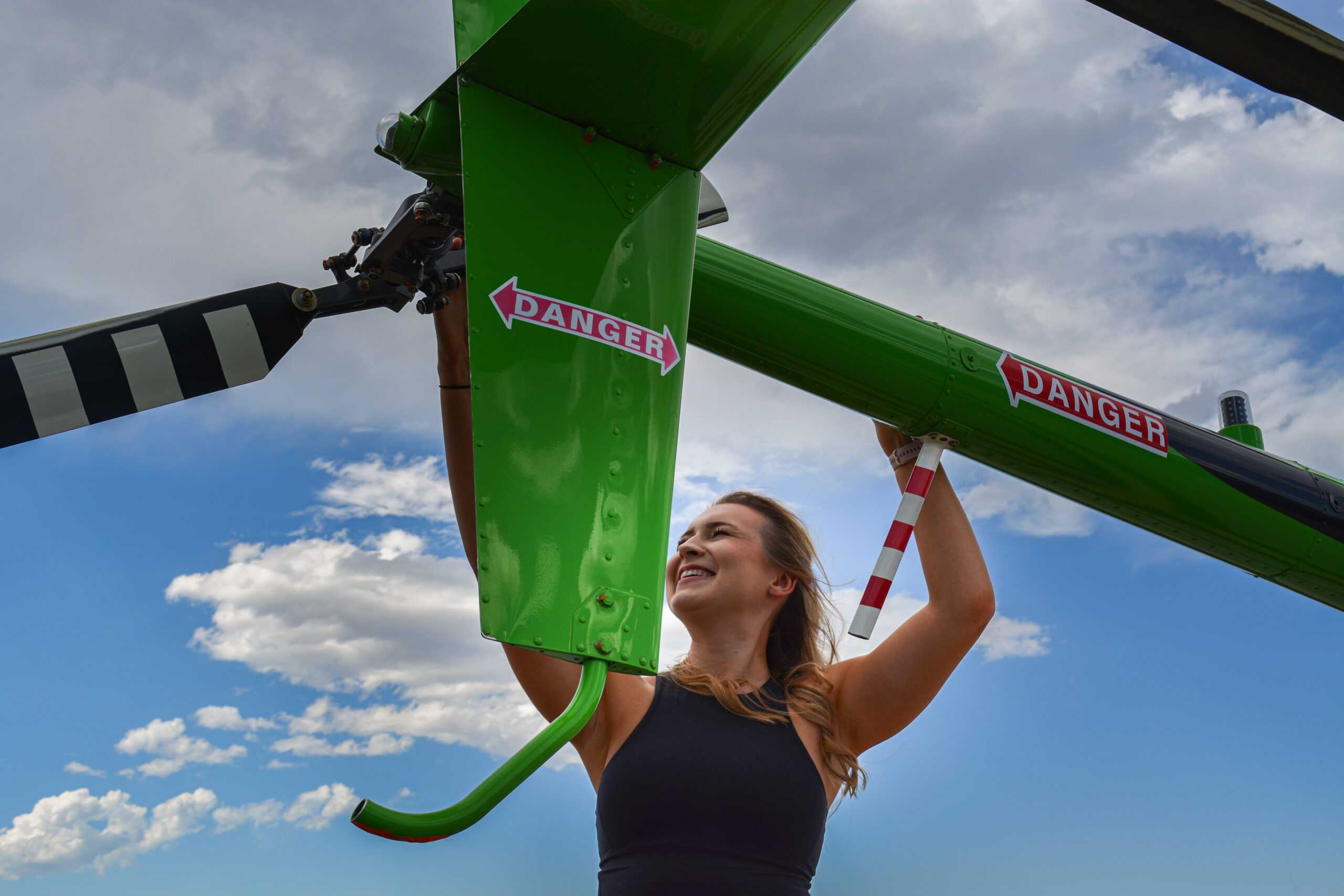 woman posing with helicopter for a blog about women in flight