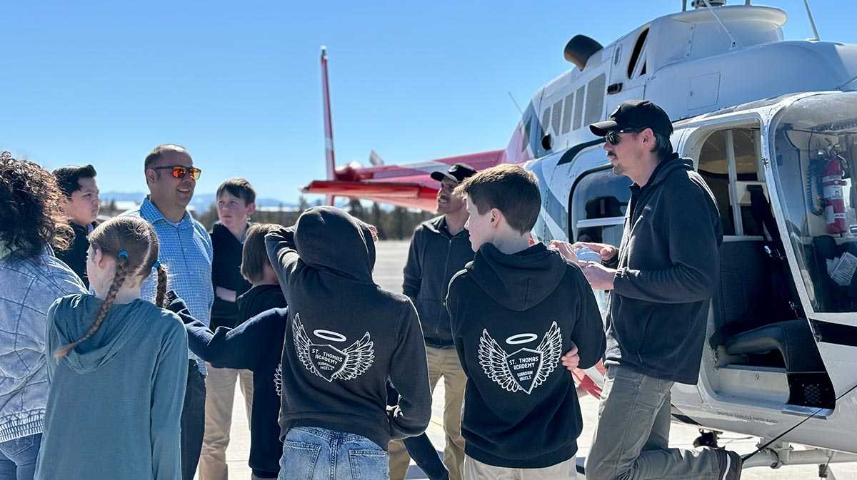 young aviation students with instructors next to helicopter for a blog about volunteer pilots