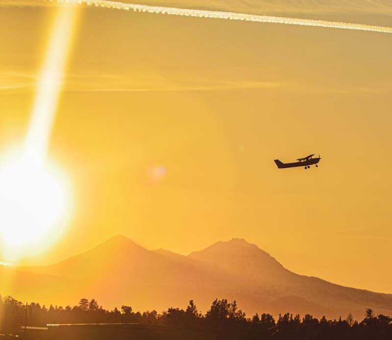 Airplane flying over sunset skies